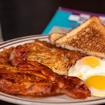 Breakfast Platter with fried eggs, hash browns, bacon and toasted bread.