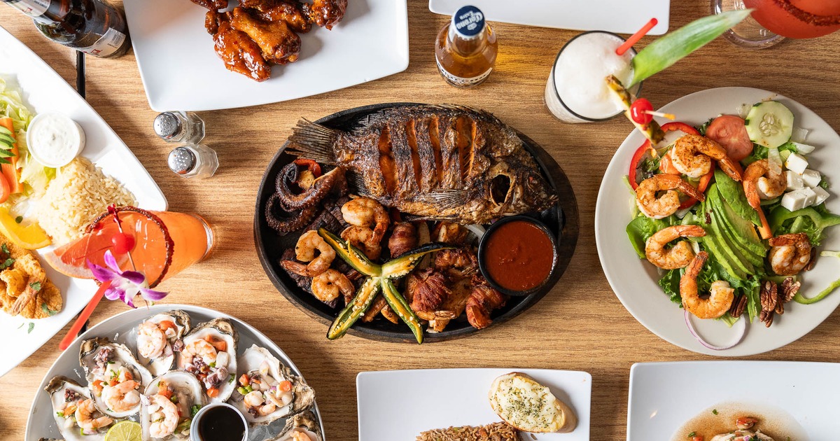 Mexican seafood feast with grilled whole fish, shrimp salad, oysters, and drinks