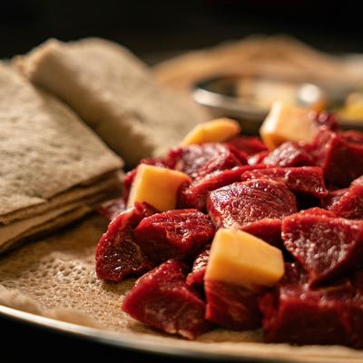 A dish of raw beef cubes served with injera flatbread.