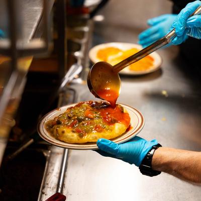 Hands preparing a meal.