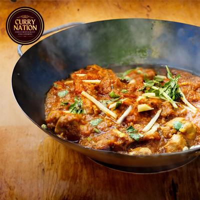 Spiced chicken curry garnished with herbs.