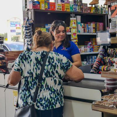 Customer paying at the register in a convenience store.