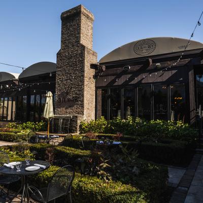 Outdoor seating area with brick fireplace, water feature and scenic landscaping.