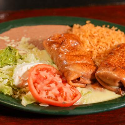 Chimichangas, with rice, beans, sour cream, guacamole, and salad.
