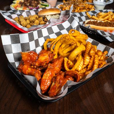 Hot wings in front assorted dishes.