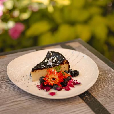 Burnt Basque Cheesecake garnished with berries and flowers.