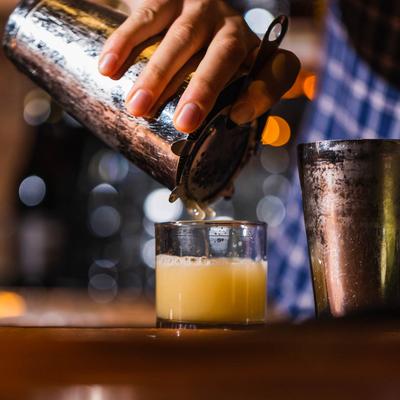 Bartender pouring a cocktail.