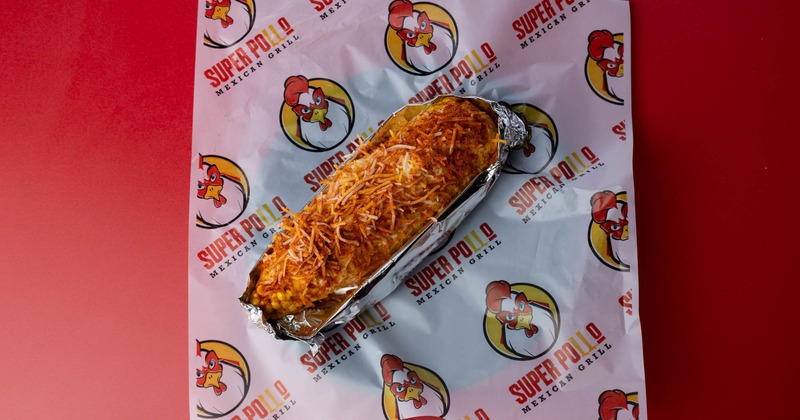 Corn on the cob with grated cheese and seasoning