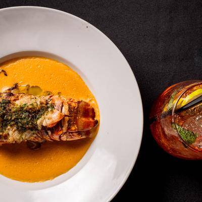 Lobster tail and seafood bisque, accompanied with a cocktail