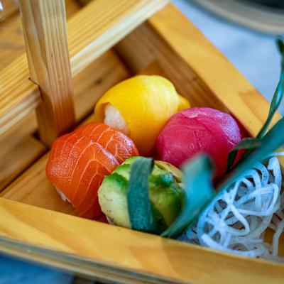 Sailboat platter featuring vibrant pieces of salmon, tuna, and avocado nigiri, close-up.
