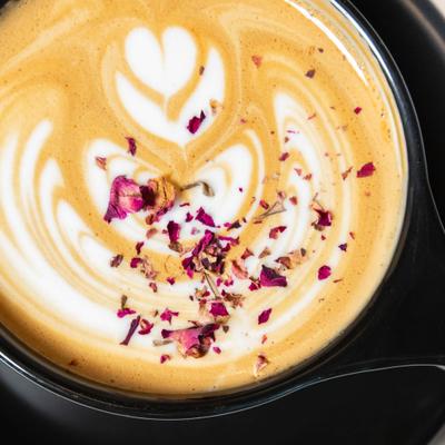 Latte with heart-shaped art topped with dried rose petals.