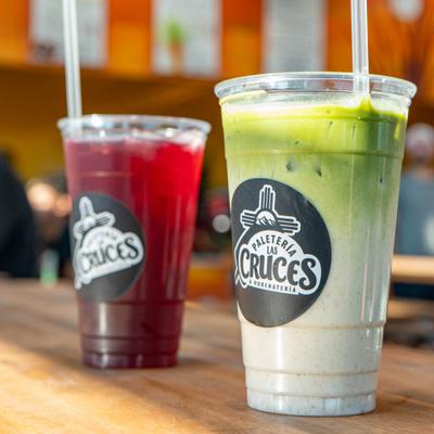 Horchata matcha and a dark red iced drink served in branded plastic cups.