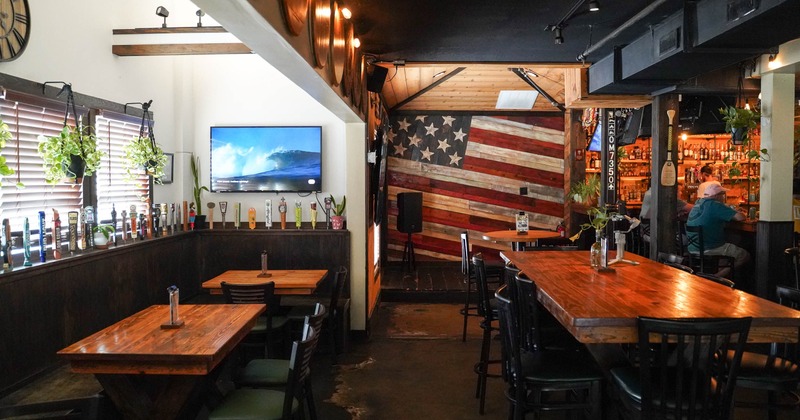 Rustic dining area with wooden tables and a large American flag wall