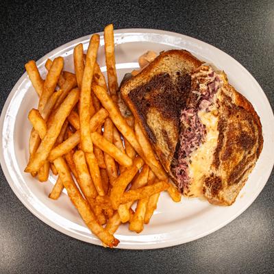 Reuben sandwich on a rye bread, served with fries.