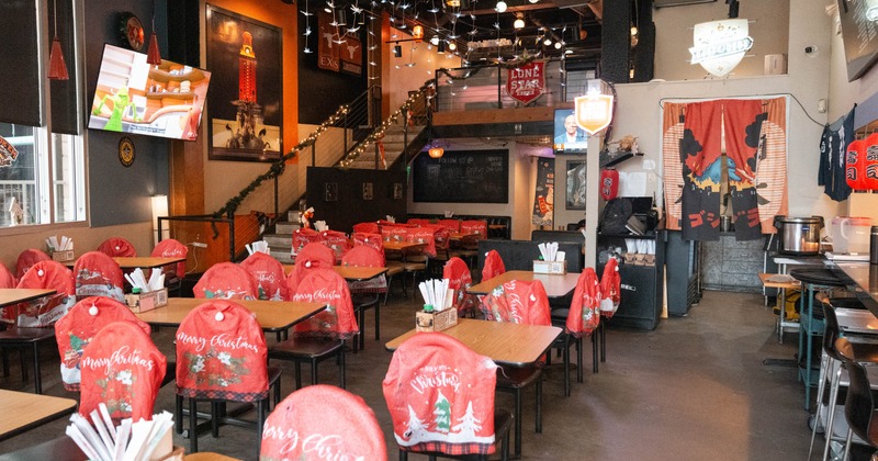 Restaurant interior with red Christmas-themed chair covers and festive decorations