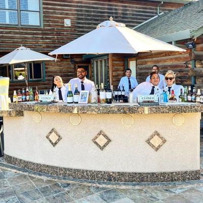 An outdoor bar with staffers behind the counter.
