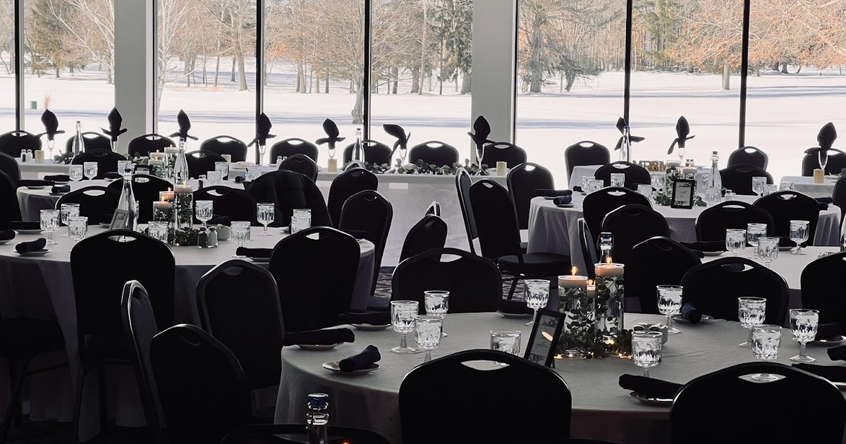 A ballroom with tables and candles overlooking the 18th green.