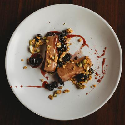 Chocolate mousse bars, garnished with crushed pistachios and dried cherries.