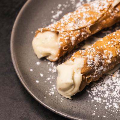 Cannoli dusted with powdered sugar, close-up.