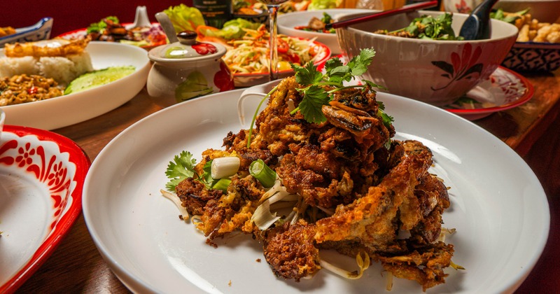 Crispy fried seafood garnished with green onion and herbs, served with a dip