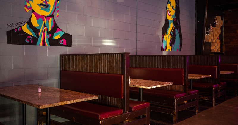 Dining booths by a wall decorated with mural art