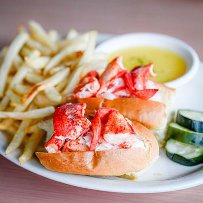 Lobster Roll served with butter and French fries.