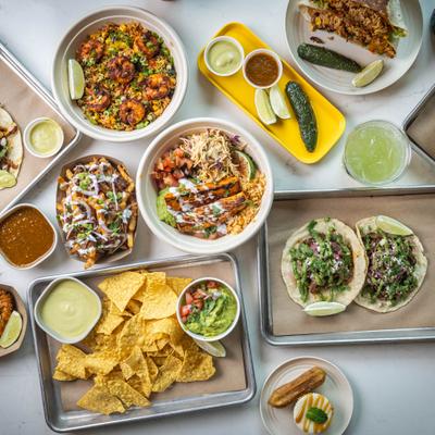 An assortment of colorful Mexican dishes, including tacos, chips, and guacamole.