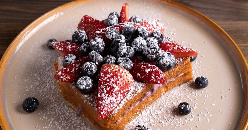 French toast topped with berries and powdered sugar