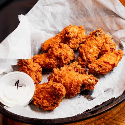 Fried Chicken wings served with a side of dipping sauce.
