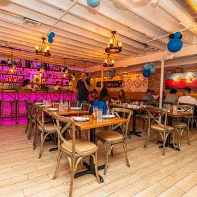 Interior, bar and dining area with place settings on tables, guests dining.