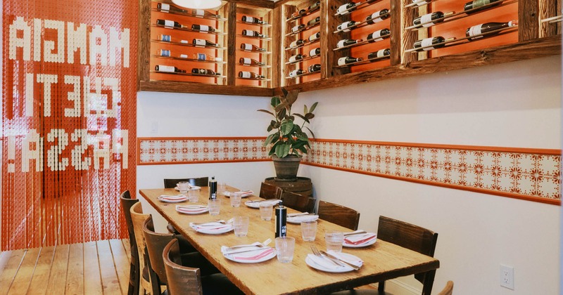 Restaurant dining room with a wooden table set for eight
