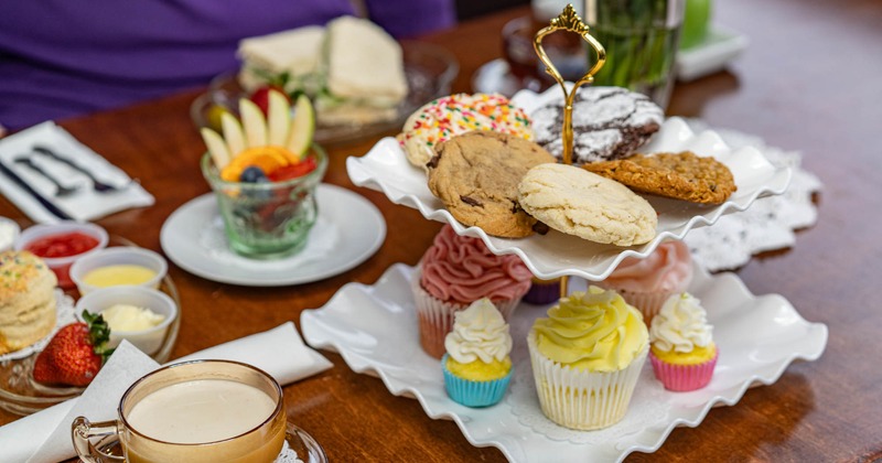Various cupcakes and cookies on a tiered platter