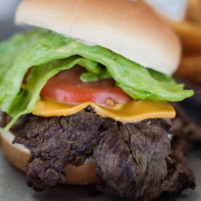 Grilled ribeye sandwich, with lettuce, tomato, and cheese.