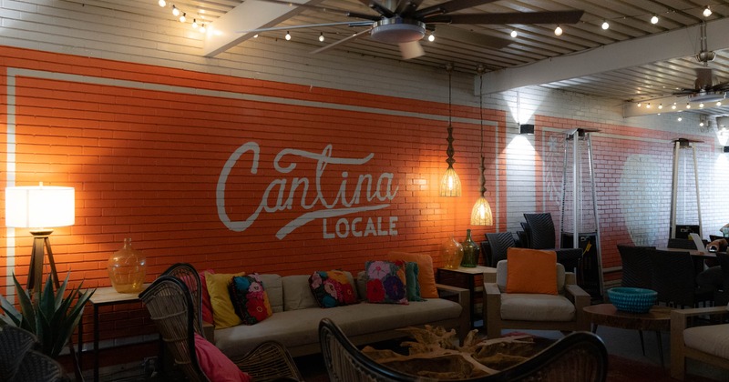A cozy lounge with "Cantina Locale" painted on an orange brick wall