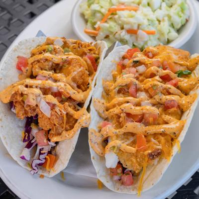 Baja Tacos with shrimp and fish, alongside a bowl of coleslaw.