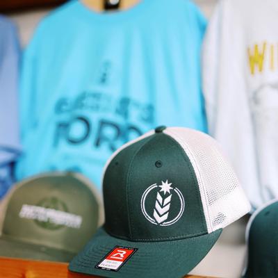 Green and white brewery logo cap on display.