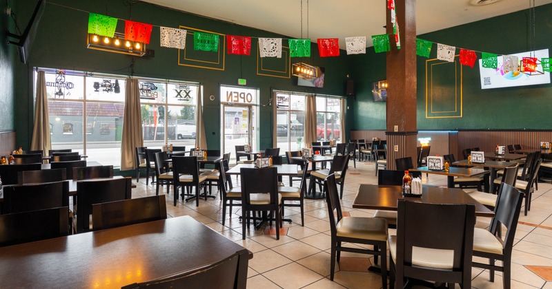 Interior, dining area, entrance, large shop window, tables ready for guests, pennants with flags