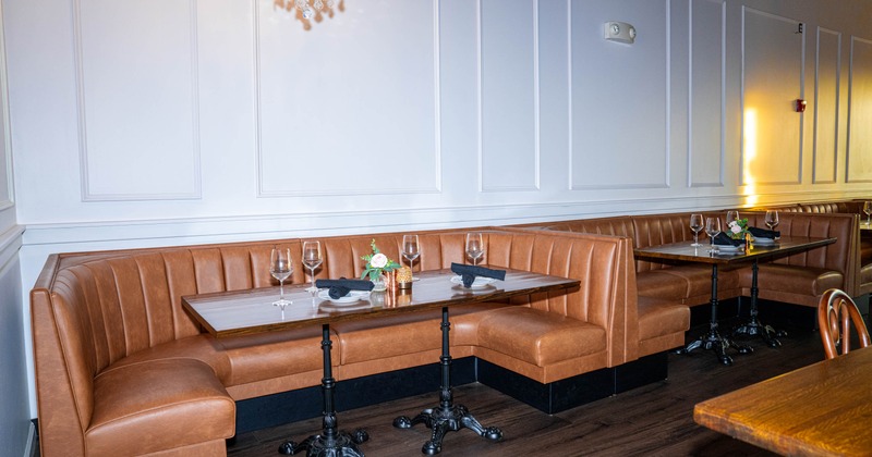 Restaurant interior with leather booths, wooden tables, and decorative lighting