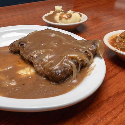 Fried steak with mashed potatoes and gravy, closeup.