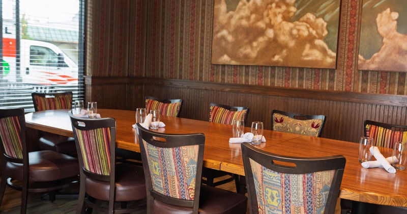 Interior, dining area, long wooden top table for ten, vintage pattern wallpaper