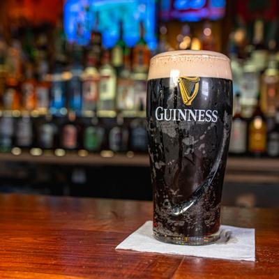 Glass of dark beer served on the bar counter.