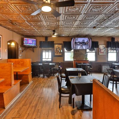 Interior with a mix of booth and table seating and multilpe TV screens.