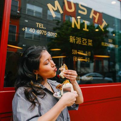 Person eating a sandwich outside the restaurant.