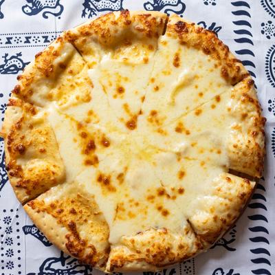 Georgian cheesebread (Megruli Khachapuri) on blue and white tablecloth