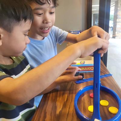 Two children playing a tabletop game.