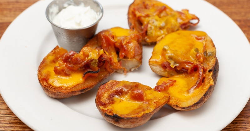 Potato with cheese and ham served with dip