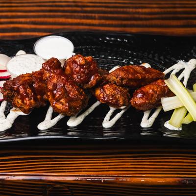 Spicy wings with celery and dipping sauce.