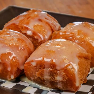 Fried mantou drizzled with a glossy white glaze, close-up.