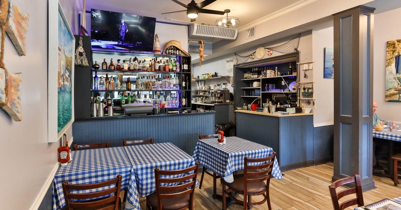 Interior with checkered tablecloths, a bar area and nautical decor.