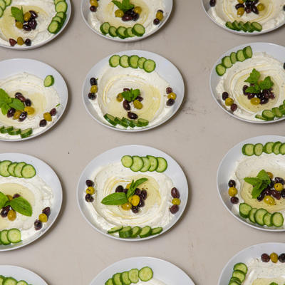 Plates of white sause and cucumbers lined up